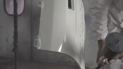 Painter paints a car bumper in white Vidéo 106597279