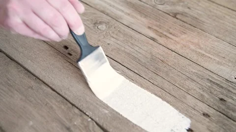 A painter paints old boards with white paint. Stock Footage 151579360