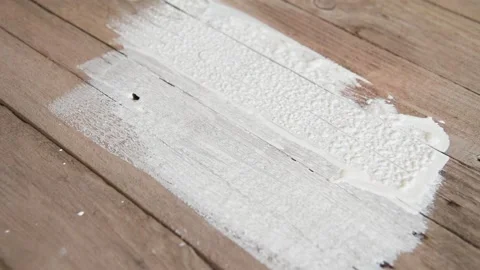 A painter paints old boards with white paint. Stock Footage 151579421