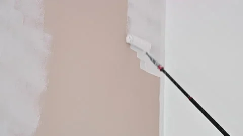 Painter paints the wall. close-up of paint roller 库存影片 166084668