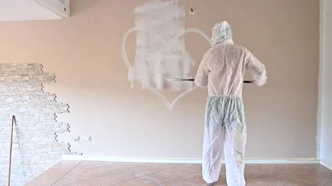 Painter paints the wall. A man paints a wall with a roller. 스톡 동영상 166176575