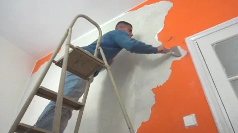 Painter peeling off old paint from wall Stock Footage 48385224