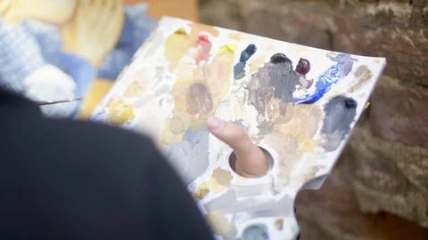 Painter picking and mixing colors on color palette. Stock Footage 129021701