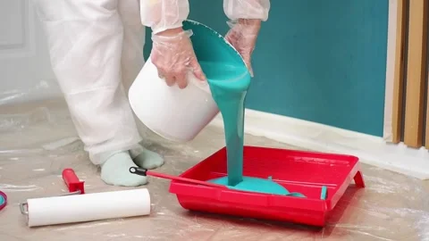 Painter pouring teal paint into a tray Video stock 308018385