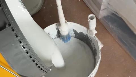 Painter pouring white paint into a bucket for house renovation Видео 341363378