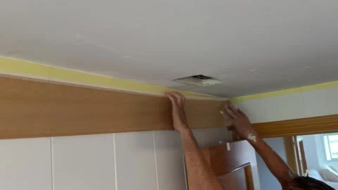 Painter preparing a bathroom for painting with masking tape Видео 341363404
