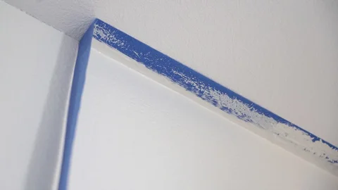 Painter removing masking blue tape from ceiling. Stock Footage 129141389