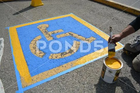 Painter repainting handicap parking on street pavement Stock Photos