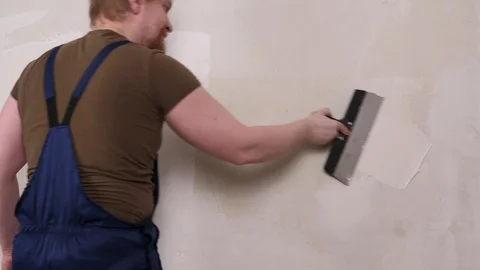 Painter with spatula covers the wall with plaster. Stock Footage 129032481
