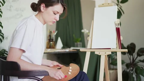 Painter squeezes the paints on the palette. Talented artist works in her studio Stock Footage 157265725