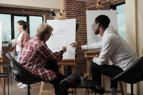 Painter teacher supervising student explaining sketching technique Stock Photos