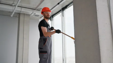 Painter in uniform painting wall with roller in home Stock Footage 281206592