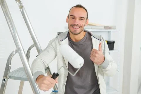 Painter use paint roller on white wall Stock Photos