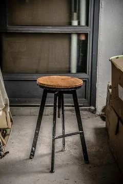 A painter uses an iron log bench placed on an indoor concrete floor Stock Photos