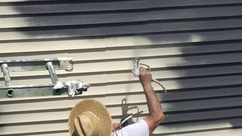 Painter uses spray gun to apply new color to house Revere Mass. USA June 21 2015 Stock Footage 312123669