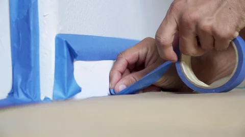 Painter Using Masking Blue Tape to Secure Baseboard, Moulding. Renovation. Stock Footage 129138606