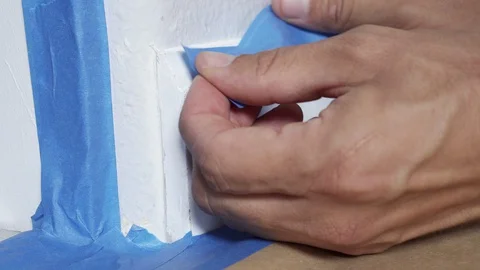 Painter Using Masking Blue Tape to Secure Baseboard, Moulding. Preparation Fo Stock Footage 129138895