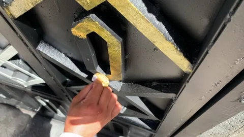 Painter using small sponge add golden paint to black gate DIY Stock Footage 232994965