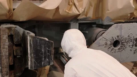 A painter in a white coat covering from head to toe protects the worker from Stock Footage 196357644