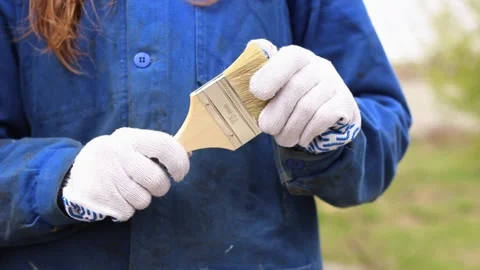 Painter in work clothes and protective gloves holds a brush Stock-Footage 334320995