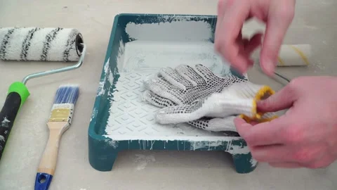 Painter worker puts on protective gloves and prepares for painting Stock Footage 125708844
