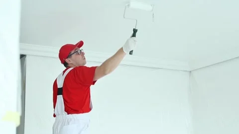 Painter worker with roller painting ceiling surface into white Video stock 131397253