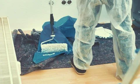 Painter working with paint roller and brushes to paint the room Stock Photos
