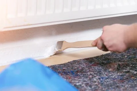Painter working with paint roller and brushes to paint the room Stock Photos