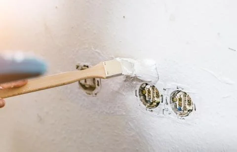 Painter working with paint roller and brushes to paint the room Stock Photos
