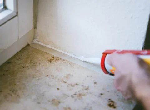 Painter working with paint roller and brushes to paint the room Stock Photos
