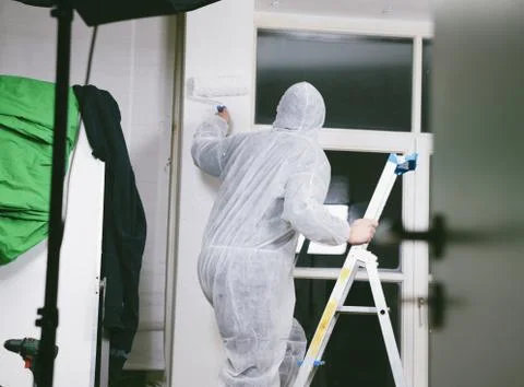 Painter working with paint roller and brushes to paint the room Stock Photos