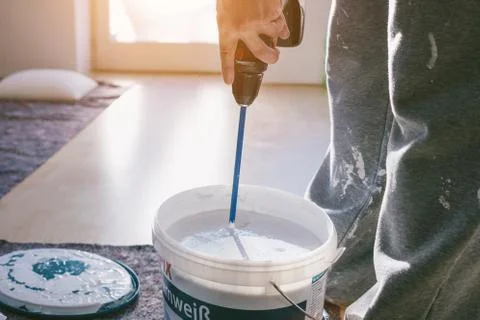 Painter working with paint roller and brushes to paint the room Stock Photos