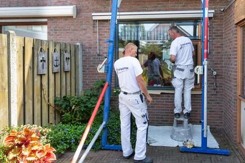 Painters preparing a house window frames for new painting Stock Photos