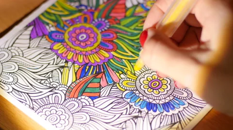 Painting adult coloring book at evening home by reading-lamp light Stock Footage