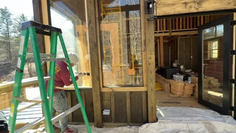 Painting and staining a front wall of cabin Stock Footage 336807306