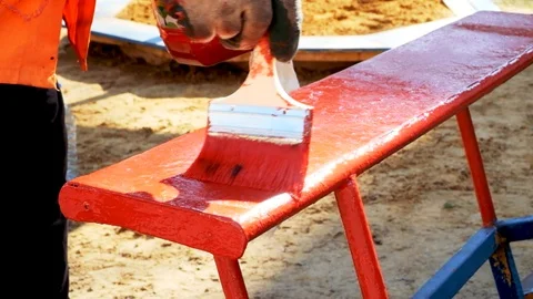 Painting with a brush to paint the elements of the playground in red Stock Footage 129094921
