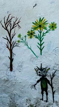 Painting of a Devil with 2 small trees on a wall Foto stock
