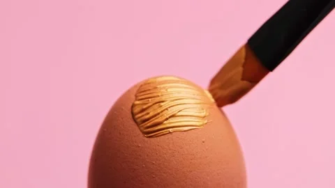 Painting Easter egg golden shine paint or beauty highlighter with paint brush Stock Footage 146476402