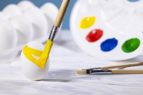 Painting Easter eggs, Preparation for spring holiday, Yellow egg with palette Stock Photos