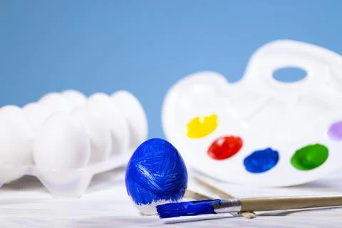 Painting Easter eggs, Preparation for spring holiday, Blue egg with palette o Stock Photos