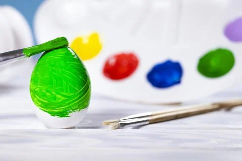 Painting Easter eggs, Preparation for spring holiday, Green egg with palette Stock Photos