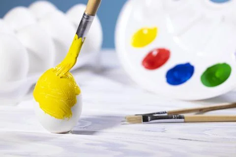 Painting Easter eggs, Preparation for spring holiday, Yellow egg with palette Stock Photos