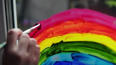Painting a rainbow with paints on a window close-up Stock Footage 139065609