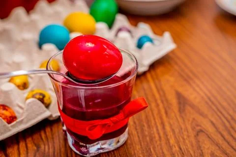 Painting a red easter egg in a with paint. Stock Photos