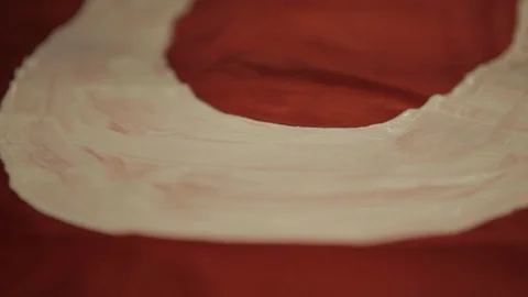 Painting onto Red Fabric Using White Paint Stock Footage 102574455