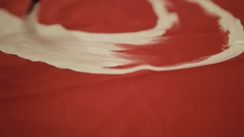 Painting onto Red Fabric Using White Paint Stock Footage 102574456