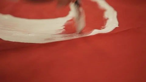 Painting onto Red Fabric Using White Paint Stock Footage 102574546