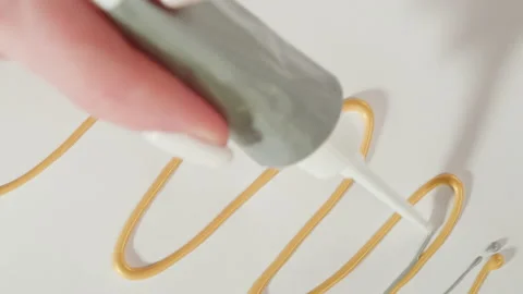 Painting silver line close-up. Squeezing grey paint out of a tube. Craft Stock Footage 178609880