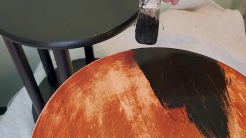 Painting small sanded side table black while finished nesting table stands in 스톡 동영상 336848171
