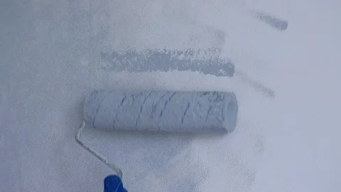 Painting wall in gray using paint roller, closeup front view. Stock Footage 123412222